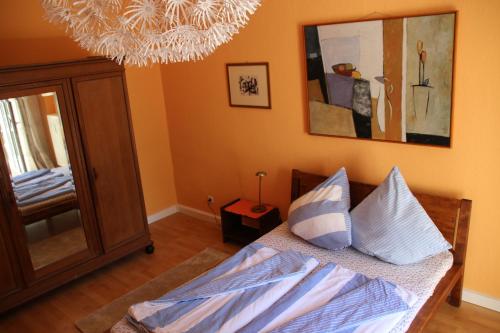 a bedroom with a bed with a mirror and a chandelier at Apartment Alaune in Dresden