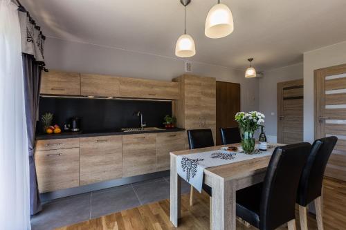 a kitchen and dining room with a table and chairs at Giewont Residence in Kościelisko