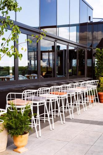a row of white tables and chairs in front of a building at The Broadview Hotel in Toronto