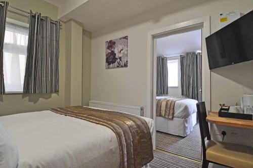 a hotel room with a bed and a television at RBS Hotel in Rochester