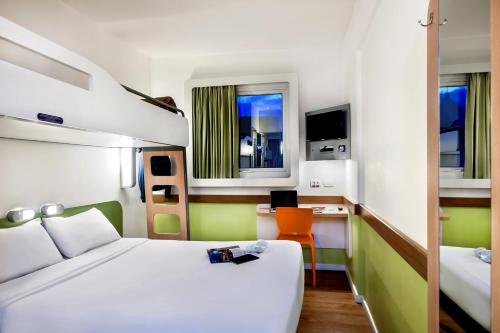 a hotel room with a bed and a desk and a bed at ibis budget Porto Alegre - Super Econômico in Porto Alegre
