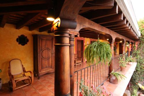 a porch of a house with a bench and plants at Hotel Palacio de Doña Beatriz in Antigua Guatemala