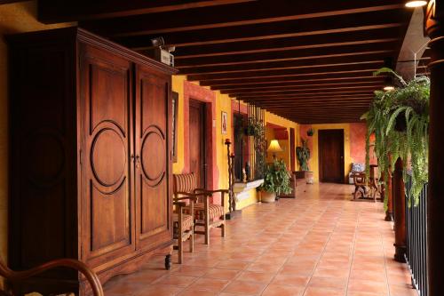 a hallway with tables and chairs in a building at Hotel Palacio de Doña Beatriz in Antigua Guatemala