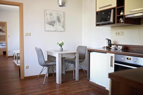a small kitchen with a white table and chairs at Penzion Sokolská in Zlín