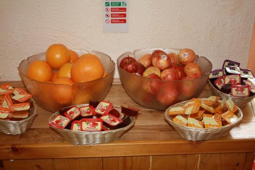four bowls of fruit and snacks on a wooden table at Sandyford Hotel in Glasgow