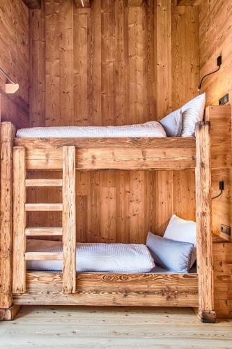 two bunk beds in a sauna with wooden walls at Chalet Stern in Vipiteno