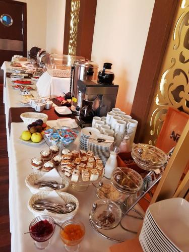 a buffet line with dishes of food on a table at Pensjonat & Spa Raj in Rajgród