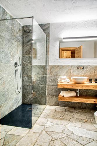 a bathroom with a glass shower and a sink at Chalet Stern in Vipiteno
