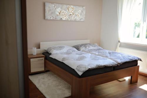 a bed in a bedroom with a picture on the wall at Penzion Sokolská in Zlín