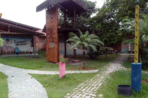 a building with a pavilion with a palm tree at Pousada Taruma in Mucuri