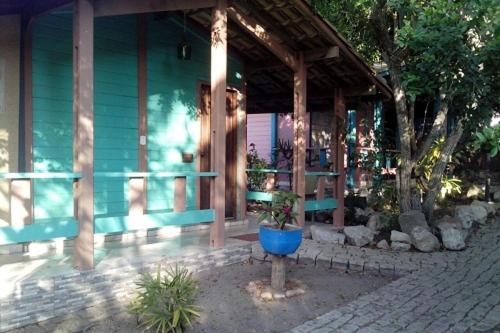 a blue building with a potted plant in front of it at Pousada Taruma in Mucuri