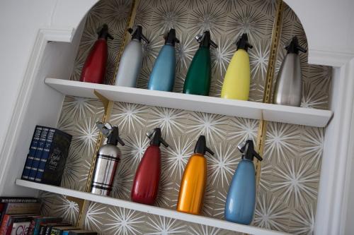 a shelf filled with different colored glass bottles at Norbury House Stylish Accommodation in Ilfracombe
