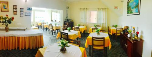 a restaurant with tables and chairs with yellow table cloth at Hotel Casarão in Peruíbe