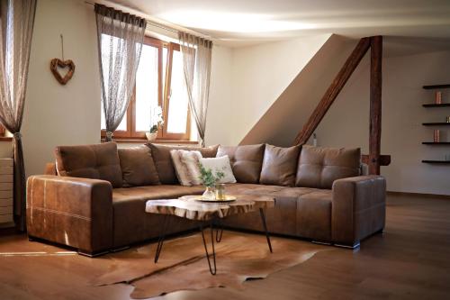 a brown couch in a living room with a table at Penzion Sokolská in Zlín