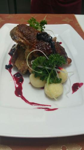 a plate of food with meat and potatoes on a table at Pensjonat & Spa Raj in Rajgród