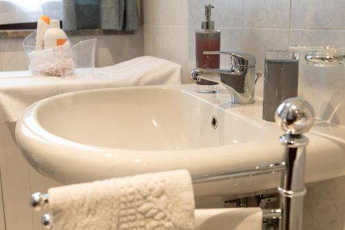 um lavatório branco na casa de banho com uma toalha em Le Joli Rosier em Nus