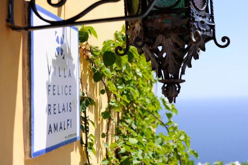 a sign on the side of a building with plants at Hotel Villa Felice Relais in Amalfi