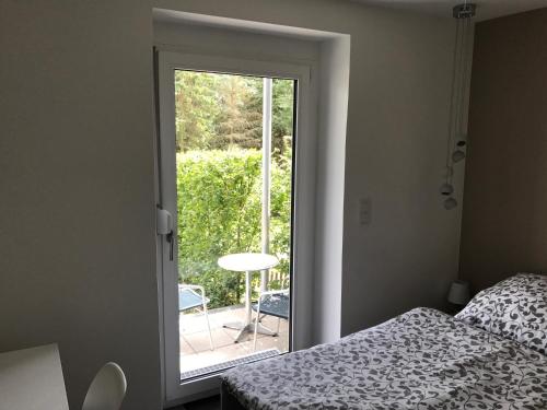 - une chambre avec un lit et une porte donnant sur une terrasse dans l'établissement Wander- und Aktivchalet, à Birkenfeld
