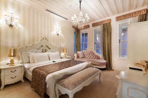 a bedroom with two beds and a chandelier at Elegance East Hotel in Antalya