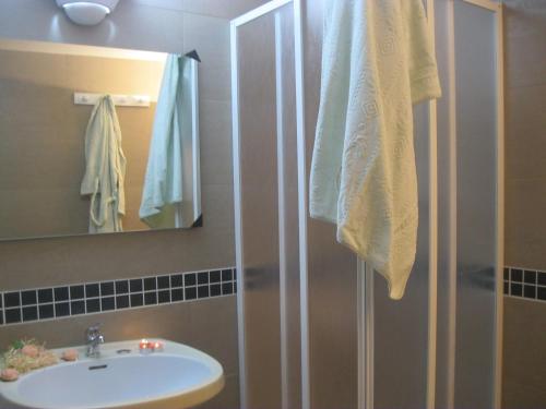 a bathroom with a shower with a sink and a mirror at Casa "Settima essenza" in Surbo