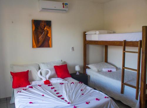 a bedroom with two bunk beds with red pillows at Pousada Pé na Areia in Pipa
