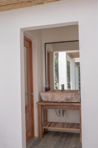 a bathroom with a sink and a mirror at Aaki Hotel in Las Peñitas