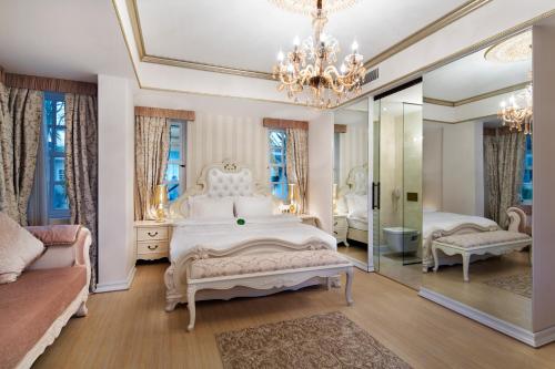 a bedroom with a white bed and a mirror at Elegance East Hotel in Antalya