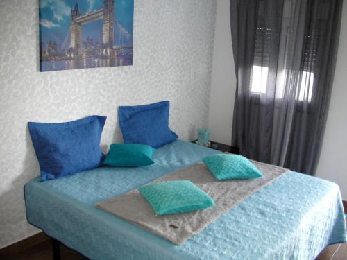 a bedroom with a blue bed with blue pillows at Alojamento Costa & Dias in Vila Verde
