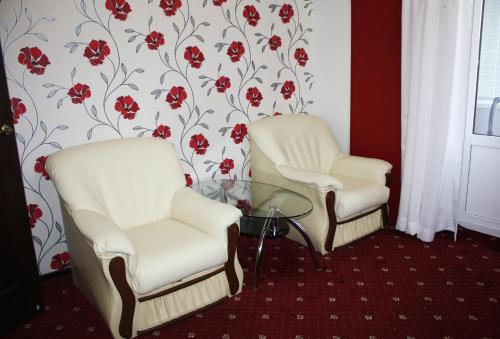 two white chairs and a glass table in a room at Квартира в Бендерах на Солнечном in Bender