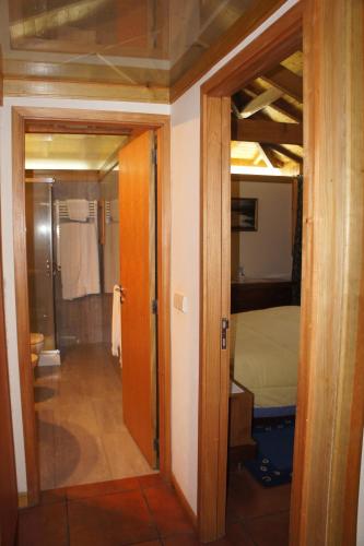 a hallway to a bedroom with a bed and a bathroom at Quinta Travessa in Vieira do Minho