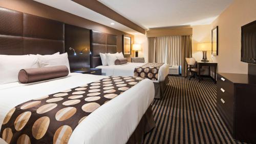 a hotel room with two beds and a desk at Sonesta Essential Indianapolis Airport in Plainfield