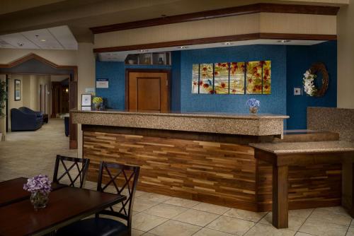 a bar in a restaurant with two tables and chairs at Best Western Plus Goldsboro in Goldsboro