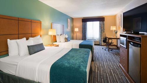 a hotel room with two beds and a flat screen tv at Quality Inn Perryton in Perryton