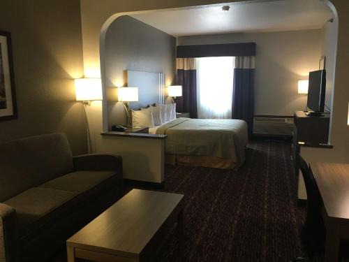una camera d'albergo con letto e divano di SureStay Plus by Best Western Edmond a Edmond