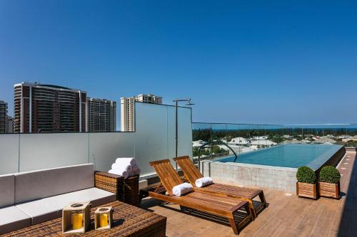 uma varanda com um banco e uma piscina em Vogue Square Fashion Hotel by Lenny Niemeyer no Rio de Janeiro