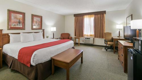 a hotel room with a large bed and a desk at Best Western La Grande Hacienda in Cherokee