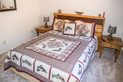 ein Schlafzimmer mit einem Bett und zwei Nachttischen in der Unterkunft Aspen Meadow Cabin in Duck Creek Village