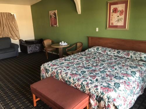 A bed or beds in a room at Galleria Inn Montclair/Ontario