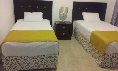 a bedroom with two beds and a night stand at Room in Cancun Stadium in Cancún