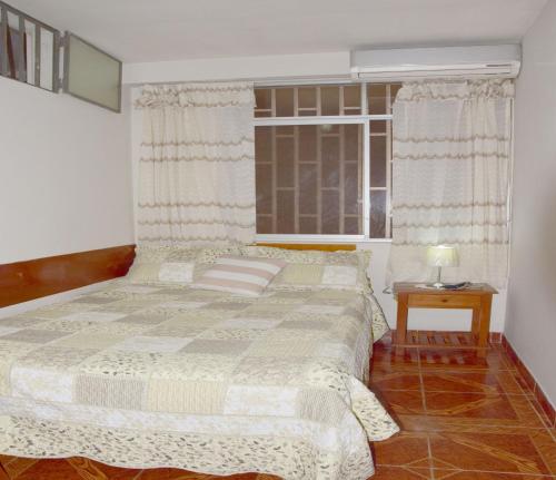 - une chambre avec un grand lit et une fenêtre dans l'établissement Casa del Huesped - Guest House, à Pucallpa