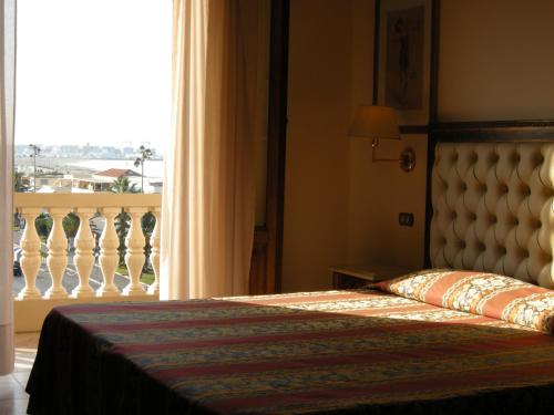 a bedroom with a bed and a window with a view at Villa Tina Hotel in Viareggio