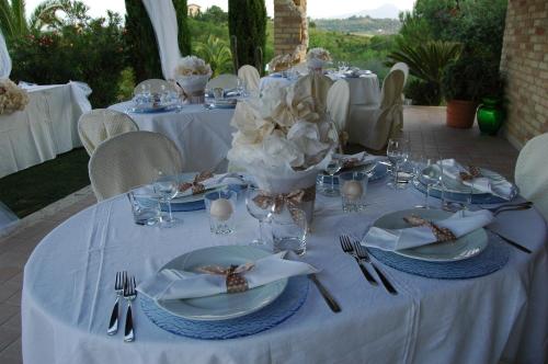 a table with white plates and silverware on it at Agriturismo Tenuta Sol Alto in Monsampolo del Tronto