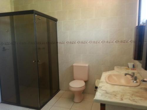 a bathroom with a shower and a toilet and a sink at Hotel La Casona in Refineria Camiri