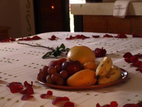 a plate of fruit on a table with flowers at Hotel Boutique La Casona de Don Porfirio in Jonotla