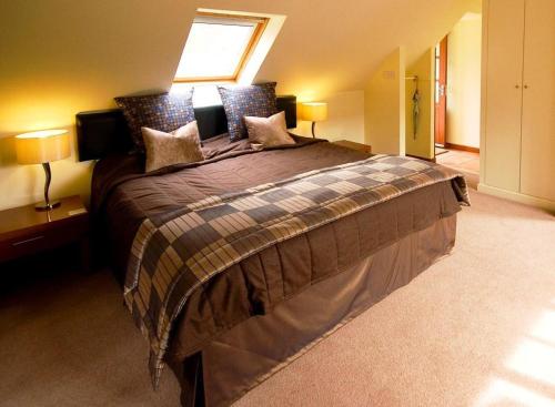 a large bedroom with a large bed with two lamps at Craigatin House & Courtyard in Pitlochry