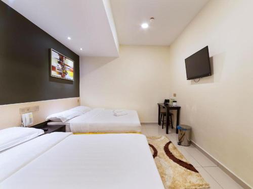 a hotel room with two beds and a flat screen tv at One Avenue Hotel in Petaling Jaya