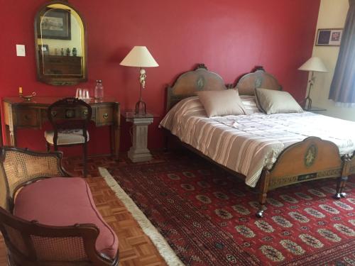 a bedroom with a large bed and a red wall at Villas Sol y Luna Coyoacan in Mexico City