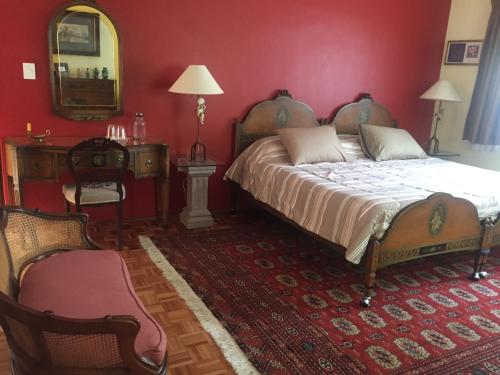 1 dormitorio con cama grande y pared roja en Villas Sol y Luna Coyoacan, en Ciudad de México