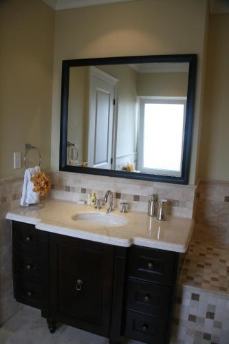 a bathroom with a sink and a large mirror at The Atrium Resort in Grace Bay