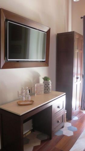 a room with a desk with a tv on the wall at Casa Rosa Gran Hotel Boutique in Puebla